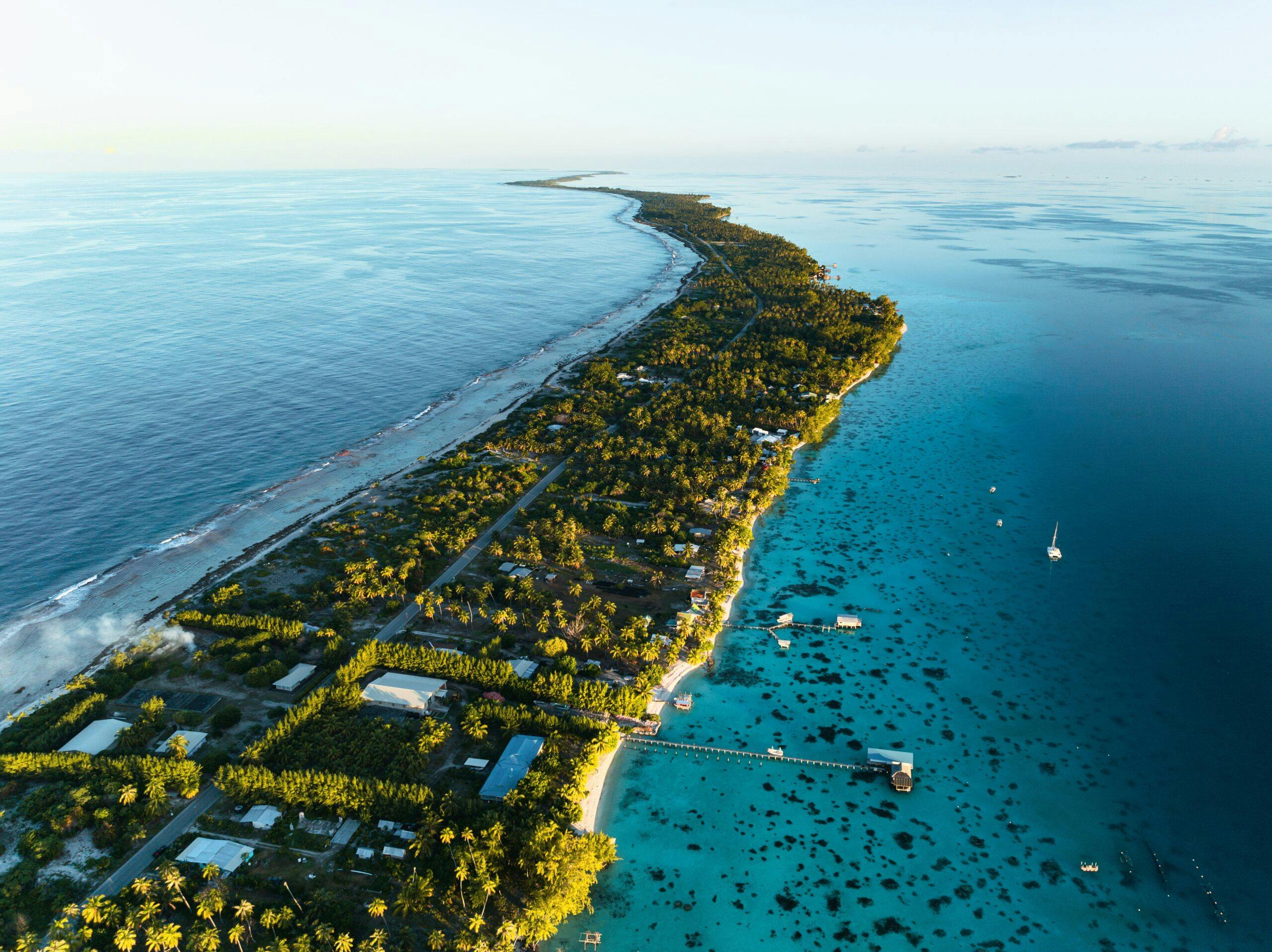Aerial view of Fakarava shows the green island scape with the bright blue ocean