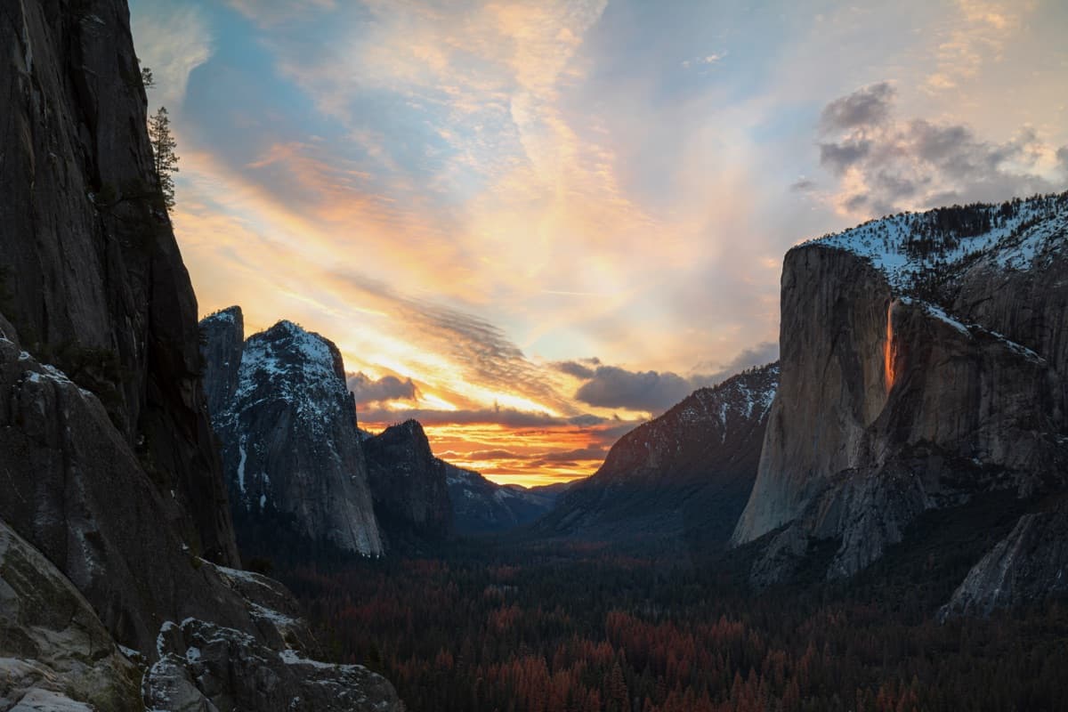 A fiery orange waterfall pours from the side of Horsetails Falls in Yosemite National Park.