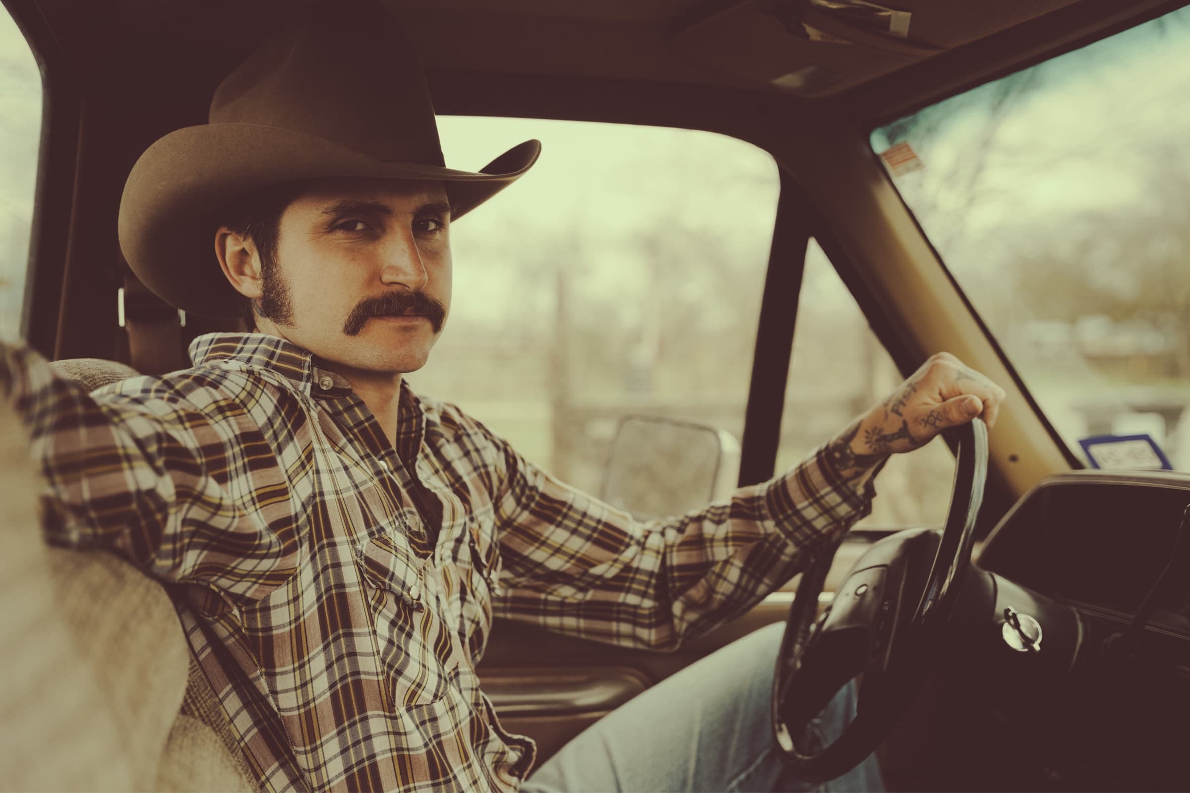 Jesse Daniel sits in the driver's seat of his truck with his hand on the steering wheel